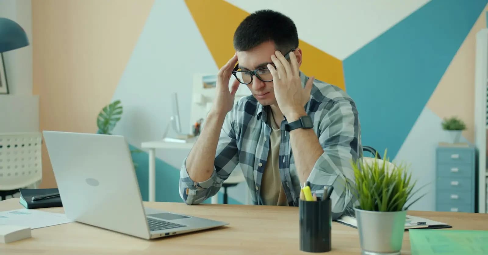 Frustrated customer holding his head at a laptop
