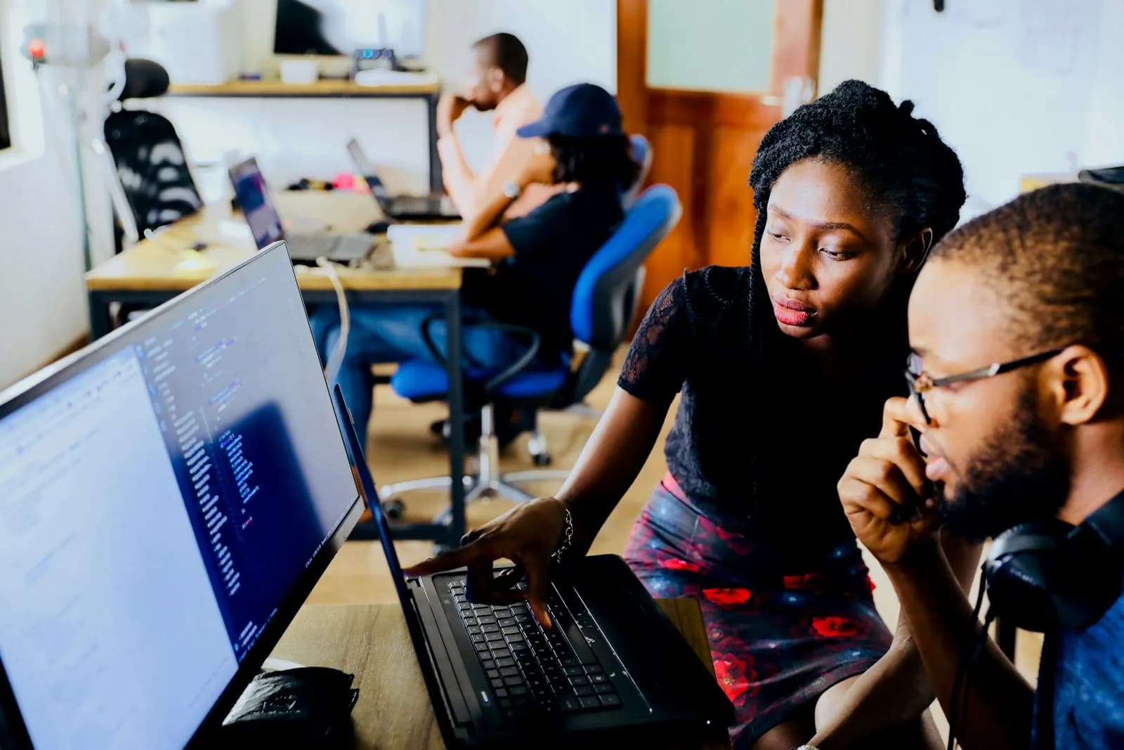 A support team working together at a laptop