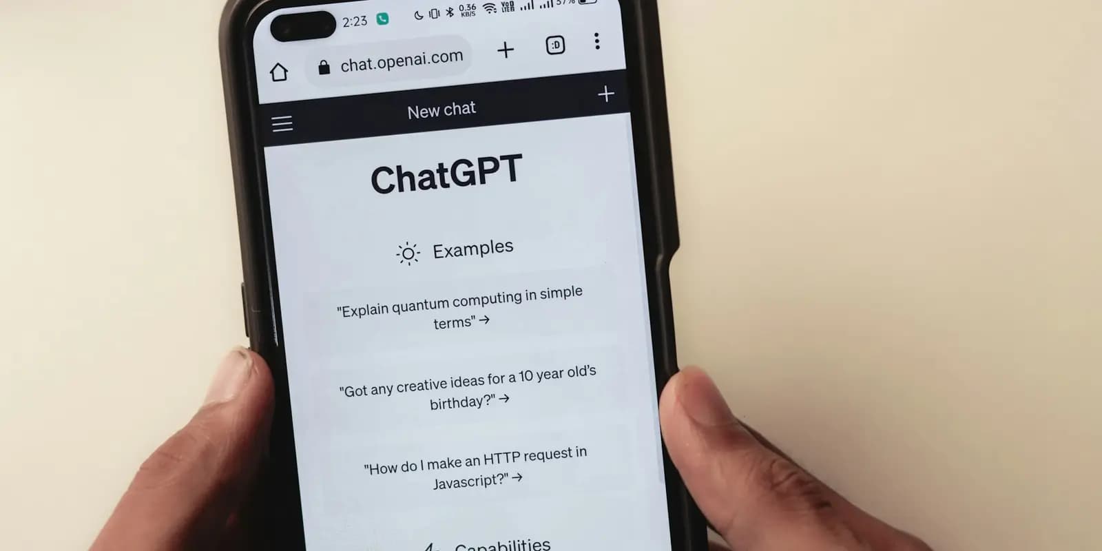 Hands holding a smartphone with ChatGPT open in the browser