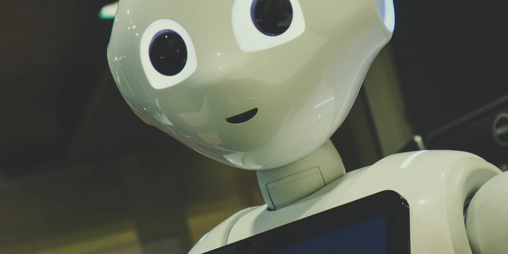A white customer service robot with a tablet screen