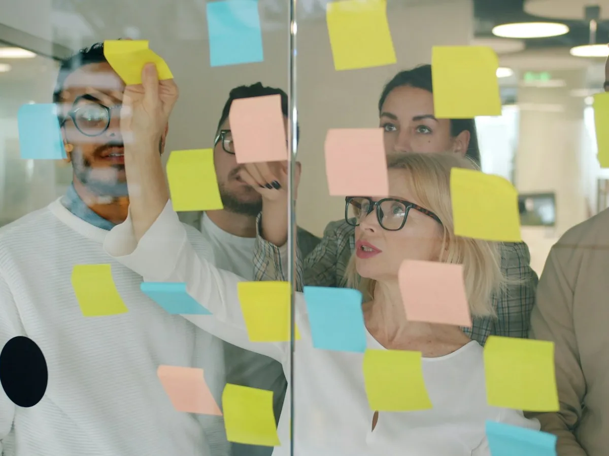 Product team planning together with sticky notes on a glass wall